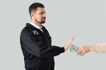 Police officer refusing to take bribe from man on grey background