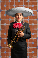 female mexican mariachi trumpetist woman smiling using a traditional mariachi girl suit on a...