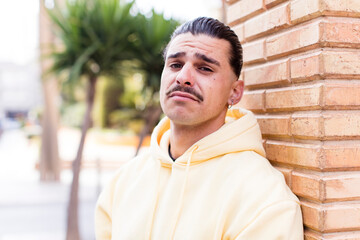 Obraz premium young cool man feeling sad and whiney with an unhappy look, crying with a negative and frustrated attitude