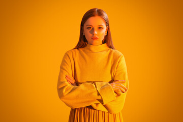 Fototapeta premium Fashionable young woman in knitted sweater on orange background