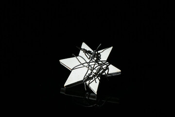 Star with barbed wire on dark background. International Holocaust Remembrance Day