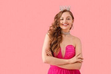 Obraz na płótnie Canvas Young woman in crown and bright prom dress on pink background