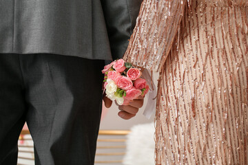 Young woman with corsage and her prom date holding hands, closeup