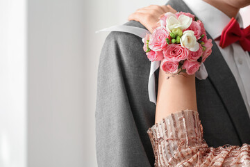 Young woman with corsage hugging her prom date, closeup