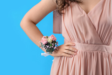 Young woman in prom dress with corsage on blue background, closeup - obrazy, fototapety, plakaty
