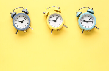 Alarm clocks on yellow background