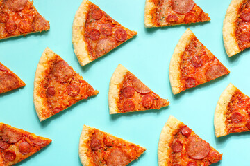 Many slices of delicious pepperoni pizza on turquoise background