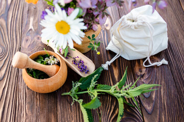 common nettle, burn nettle, stinging nettle and orange Calendula officinalis medicinal herbs near mortar. Bag with dried herbs. Soft focus