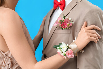 Young girl with corsage and her prom date on blue background, closeup - obrazy, fototapety, plakaty
