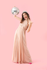 Beautiful young woman in prom dress and with disco ball on pink background © Pixel-Shot