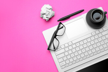 Laptop, cup of coffee, eyeglasses and pen on pink background