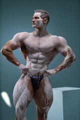 Fototapeta na wymiar Muscular man with perfect abs posing at studio