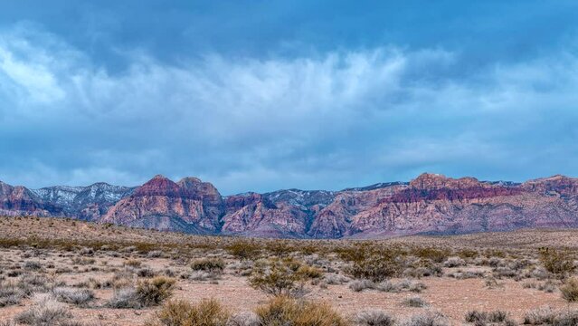 Early morning time lapse at Red Rock Canyon in Las Vegas shows the sun poking through to light up the deep red rocks of this state park