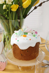 Festive table setting with traditional Easter cake and vase of tulips