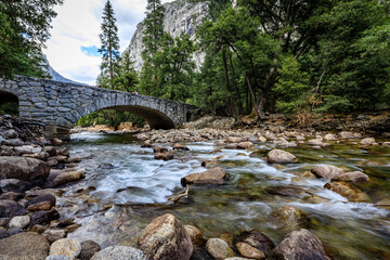 Beautiful stone bridge arching over the Merced river in Yosemite National Park