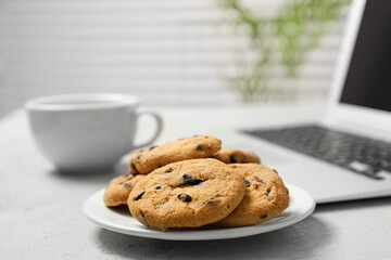 Chocolate chip cookies on light gray table in office, closeup. Space for text
