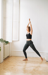 Young slim woman in sportwear doing fitness exercises, girl dancing at bright studio