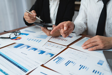 Asian businessmen use devices for business holding a smartphone and discussing administrative data analysis Marketing and Financial Growth.