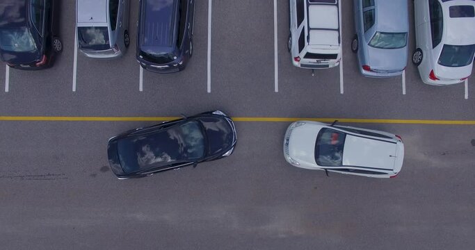 Two cars trying to get into the same parking spot, 4k drone direct overhead.