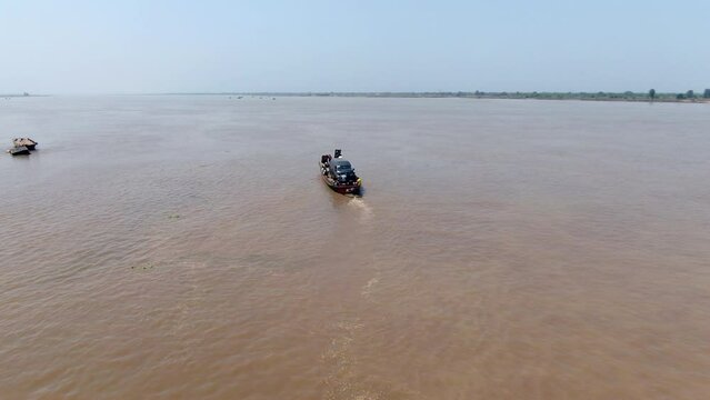 A car secured to a handmade raft for transport across Benue River by Ibi Town, Nigeria - aerial follow