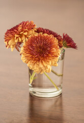 Vaso pequeño con ramillete de flores sobre superficie de madera