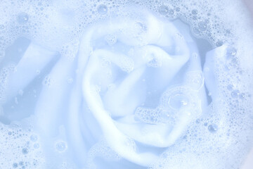 Obraz na płótnie Canvas Top view of towel soak in powder detergent water dissolution. Laundry concept