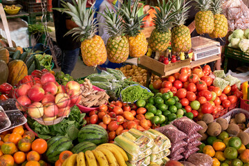 rural market place stocked with a wide variety of fruits and vegetables for sale.
