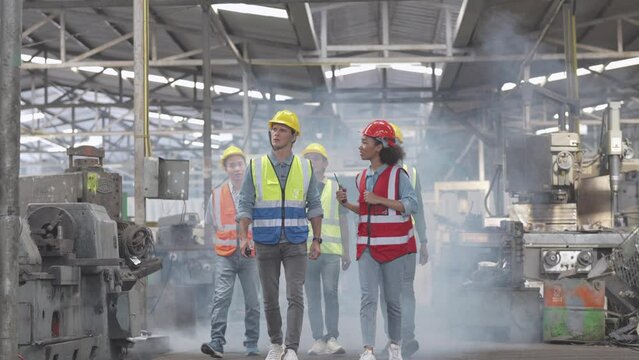 Group of Diversity factory worker people standing when success the project and celebrating together in local warehouse, asian, white caucasian and asian people in heavy machine at industry factory.