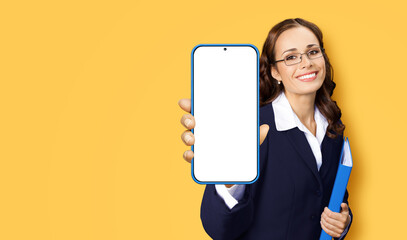 Portrait image of happy smiling woman in glasses, confident suit hold show smartphone cell phone...