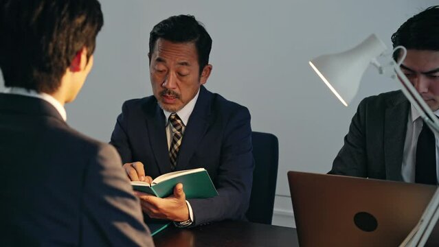取り調べする刑事と容疑者