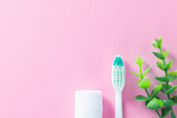 Pastel pink background with cleaning tools for oral and dental health care such as toothbrush and toothpaste. Concept: lifestyle and daily routine for a healthy mouth and teeth.