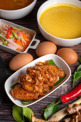 Deep fried chicken and fried onions, southern style herbs recipe, eaten with rice noodles and pickled vegetables.
