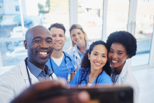 Healthcare, team and selfie by doctors at hospital, happy and proud , smile and bond on blurred background. Medical, diversity and group pose for photo, profile picture or website homepage update