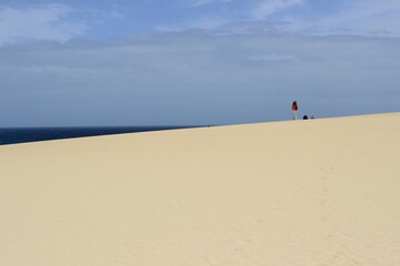 The desert dunes of Corralejo on the island of Fuerteventura. A white sand that contrasts with the blue of the ocean.