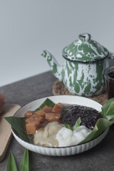 Bubur sum sum or Bubur merah putih.Traditional Indonesian dessert made from sweet glutinous rice, coconut milk, and pandanus leaf, topped with a sprinkle of red and white sugar. Closeup