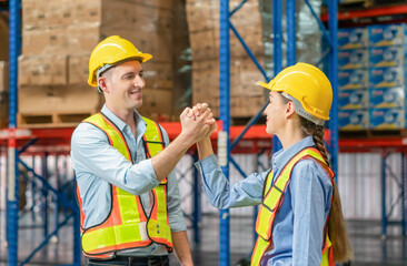 Warehouse worker shaking hands with his colleague at the industrial storage, Worker in uniform shaking hands with foreman at factory warehouse