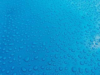 Close-up of rain drops on the blue surface