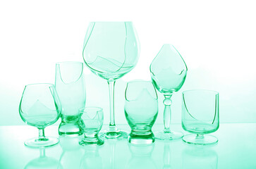 Broken empty wine glasses in blue on a white background.