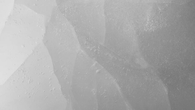 Macro crushed ice texture with splashing water surface, water drops and ripples