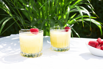 Fresh cool cocktail of melon with ice and lime slices, garnished with fresh raspberries. Summer drinks and smoothies