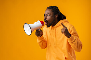 Young african man against yellow background with megaphone