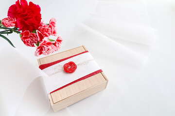 カーネーションの花束と和風ラッピングの贈り物