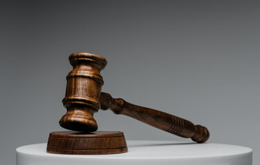 Brown wooden judge gavel on gray background