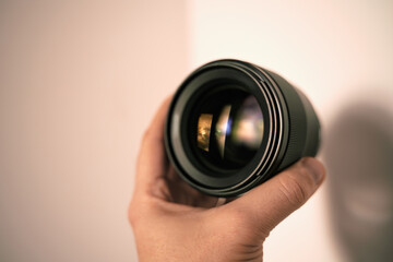 Man hand holds a portrait lens. Isolated photo of a modern lens in hand