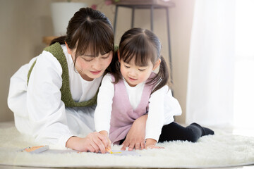 Fototapeta premium 親子で仲良しの様子 お絵描きをするかわいい女の子とママ