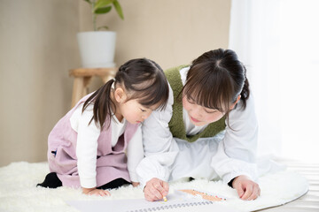 お絵描きをするかわいい女の子と母親