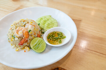 Prawn fried rice on white plate on wooden table background