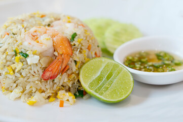 Shrimp fried rice on a white plate with fish sauce chili in a cup