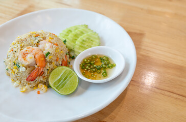 Prawn fried rice on white plate on wooden table background
