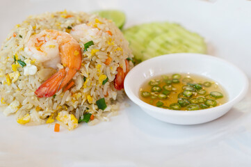 Shrimp fried rice on a white plate with fish sauce chili in a cup